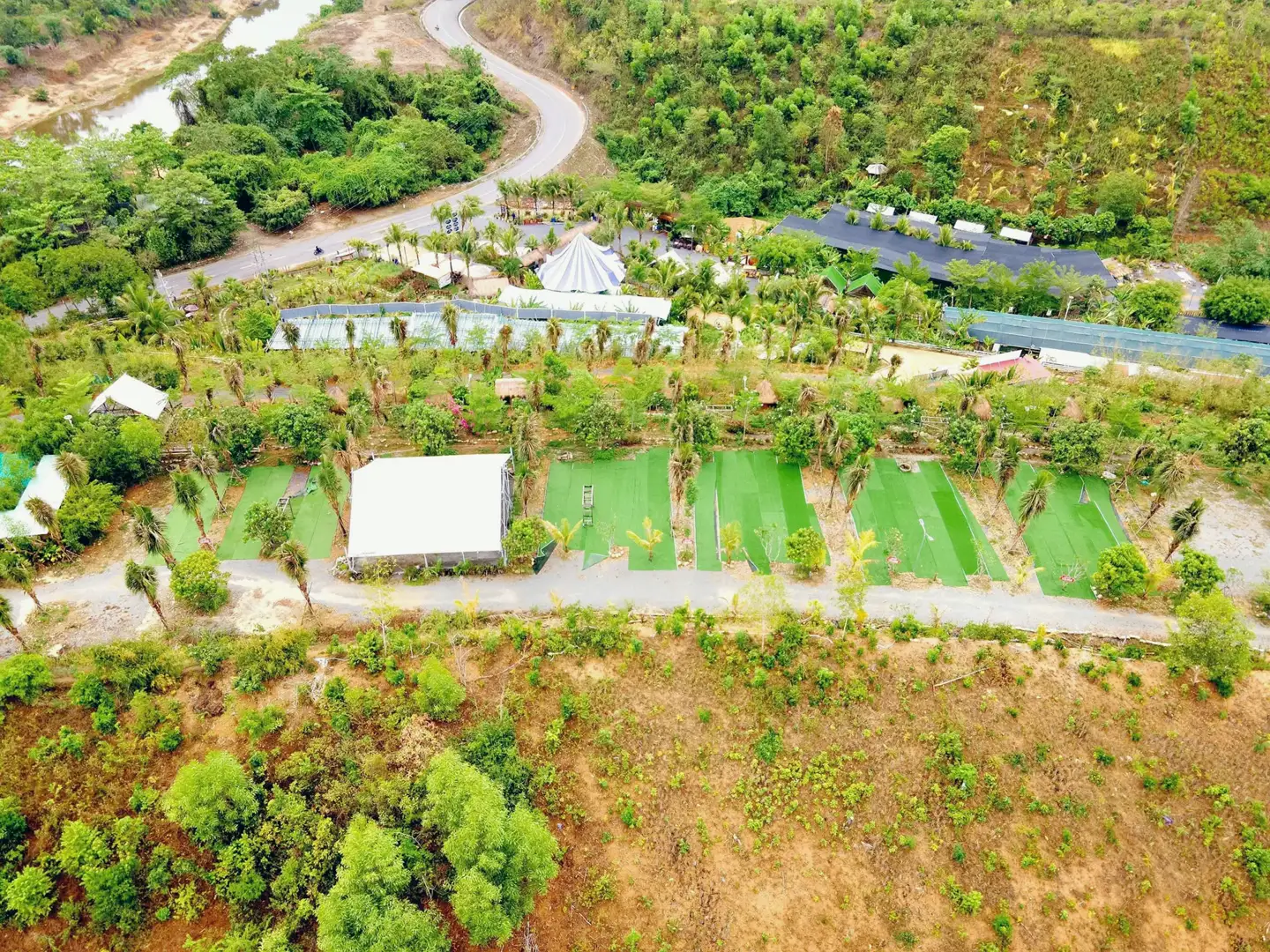Ảnh flycam toàn khu: sông, đường Nha Trang – Đà Lạt, cổng, lều rạp, nhà hàng, nhà lưới, dãy nền trên đồi